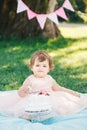 Portrait of cute adorable Caucasian baby girl with dark brown eyes in pink tutu dress celebrating her first birthday Royalty Free Stock Photo