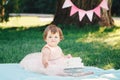 Portrait of cute adorable Caucasian baby girl with dark brown eyes in pink tutu dress celebrating her first birthday