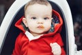 Portrait of cute adorable Caucasian little baby boy sitting in high chair in kitchen eating meal puree Royalty Free Stock Photo