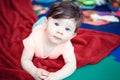 Portrait of cute adorable Caucasian smiling baby boy girl lying on floor in kids room Royalty Free Stock Photo