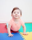 Portrait of cute adorable Caucasian smiling baby boy girl lying on floor in kids room