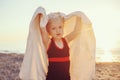 Portrait of cute adorable happy smiling toddler little girl with towel on beach making poses faces having fun Royalty Free Stock Photo