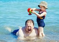 Portrait of cute adorable happy smiling toddler little girl with towel on beach making poses faces having fun Royalty Free Stock Photo