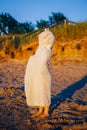 Portrait of cute adorable happy toddler little girl boy with dunes beach towel hiding covering having fun Royalty Free Stock Photo