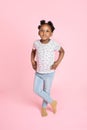 Portrait of cute adorable little African school girl in casual wear, jeans and t-shirt, posing to camera with happy Royalty Free Stock Photo