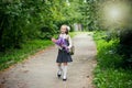 Portrait of cute adorable little caucasian school girl wearing uniform and flowers bouquet going back to school