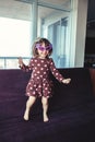 girl with funny glasses jumping dancing on couch indoors