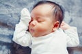 Portrait of cute adorable sleeping Asian Chinese mixed race newborn baby girl boy lying on bed in bedroom. Royalty Free Stock Photo