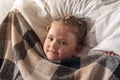 Portrait of cute adorable smiling little girl waking up and stretching in her bed Royalty Free Stock Photo