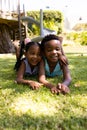 Portrait of cute african american siblings lying on grassy field in park Royalty Free Stock Photo