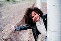 portrait of cute afro kid girl hiding behind a tree outdoors. Childhood and happiness Royalty Free Stock Photo