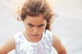 Portrait of cute angry little girl. Kid looking worried at summer day