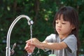 Portrait cute Asian girl aged 4 to 8 years old, washing her hands with soap from the tap. To clean her hands Frequent hand washing Royalty Free Stock Photo