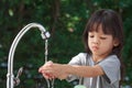 Portrait cute Asian girl aged 4 to 8 years old, washing her hands with soap from the tap. To clean her hands Frequent hand washing Royalty Free Stock Photo