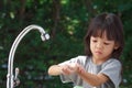 Portrait cute Asian girl aged 4 to 8 years old, washing her hands with soap from the tap. To clean her hands Frequent hand washing Royalty Free Stock Photo