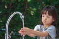 Portrait cute Asian girl aged 4 to 8 years old, washing her hands with soap from the tap. To clean her hands Frequent hand washing Royalty Free Stock Photo