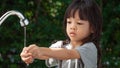 Portrait cute Asian girl aged 4 to 8 years old, washing her hands with soap from the tap. To clean her hands Frequent hand washing Royalty Free Stock Photo