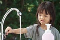 Portrait cute Asian girl aged 4 to 8 years old, washing her hands with soap from the tap. To clean her hands Frequent hand washing Royalty Free Stock Photo