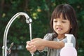 Portrait cute Asian girl aged 4 to 8 years old, washing her hands with soap from the tap. To clean her hands Frequent hand washing Royalty Free Stock Photo