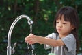 Portrait cute Asian girl aged 4 to 8 years old, washing her hands with soap from the tap. To clean her hands Frequent hand washing Royalty Free Stock Photo