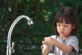 Portrait cute Asian girl aged 4 to 8 years old, washing her hands with soap from the tap. To clean her hands Frequent hand washing Royalty Free Stock Photo