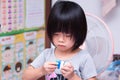 Portrait cute Asian kid girl is building plastic block on purpose. Kindergarten child playing with toys. Children are 4 years old Royalty Free Stock Photo