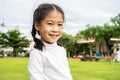 Portrait of Cute asian little girl standing in summer park looking in camera smiling happily, Laughing child, Royalty Free Stock Photo
