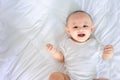 Portrait of cute asian newborn baby lying play on white bed look at camera with laughing smile happy face.