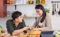 Portrait cute Asian young adult couple lover helping together, cooking in cozy home kitchen in morning, preparing breakfast meal, Royalty Free Stock Photo