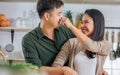 Portrait cute Asian young adult couple lover helping together, cooking in cozy home kitchen in morning, preparing breakfast meal, Royalty Free Stock Photo