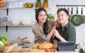 Portrait cute Asian young adult couple lover helping together, cooking in cozy home kitchen in morning, preparing breakfast meal, Royalty Free Stock Photo