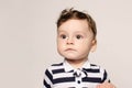 Portrait of a cute baby boy looking away surprised with his big eyes.