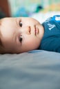 Portrait of cute baby boy lying on bed and looking at camera Royalty Free Stock Photo