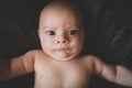 Portrait of cute baby boy makes a funny serious face. Infant frowning. Royalty Free Stock Photo