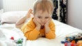 Portrait of cute baby boy relaxing on bed with toys. Child development, education and entertainment Royalty Free Stock Photo