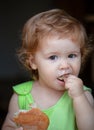 Portrait of cute baby with bread in her hands eating. Cute toddler child eating sandwich, self feeding concept. Royalty Free Stock Photo