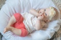 Portrait of cute baby girl lying on her back and suckling her finger. Teething. Royalty Free Stock Photo