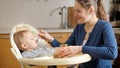 Portrait of cute baby opens mouth while spoon like airplane flies in his mouth. Concept of parenting, healthy nutrition and baby