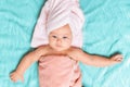 Portrait of a cute baby wrapped in a pink towel lying on a blue sheet. View from the top. Baby after bathing Royalty Free Stock Photo