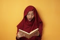 Asian Muslim Teenage Girl Wearing Hijab Shocked and Excited When Reading Book Royalty Free Stock Photo