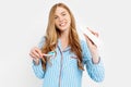 Portrait of a cute beautiful girl in pajamas and holding a tube of toothpaste and a toothbrush isolated on a white background, Royalty Free Stock Photo