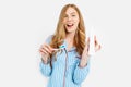 Portrait of a cute beautiful girl in pajamas and holding a tube of toothpaste and a toothbrush isolated on a white background, Royalty Free Stock Photo