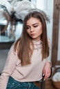 Portrait of a cute beautiful young woman in fashionable casual wear. Stylish girl fashion model with brown long hair in a pink Royalty Free Stock Photo
