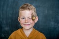 Portrait of cute blond freckled child boy with snail on face. Funny smiling child looking in camera. Children fun with