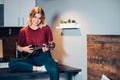 Portrait of cute blond woman playing ukulele at home on table Royalty Free Stock Photo