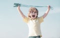 Portrait of cute boy exercising with jumping rope on blue sky background. Kid skipping rope during sunny morning. Royalty Free Stock Photo