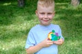 Portrait of a cute boy holding an earth model with clay rainbow. ecology concept.outdoor Royalty Free Stock Photo