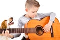 Portrait of a cute boy playing acoustic guitar with his dog Royalty Free Stock Photo