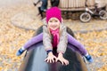 Portrait of cute caucasian blond little girl having fun playing at modern outdoor playground at city park in autumn. Adorable