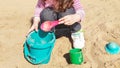 Portrait cute Caucasian toddlers babies child sitting in sandbox playing with plastic colorful toys. Little girl having fun on the Royalty Free Stock Photo